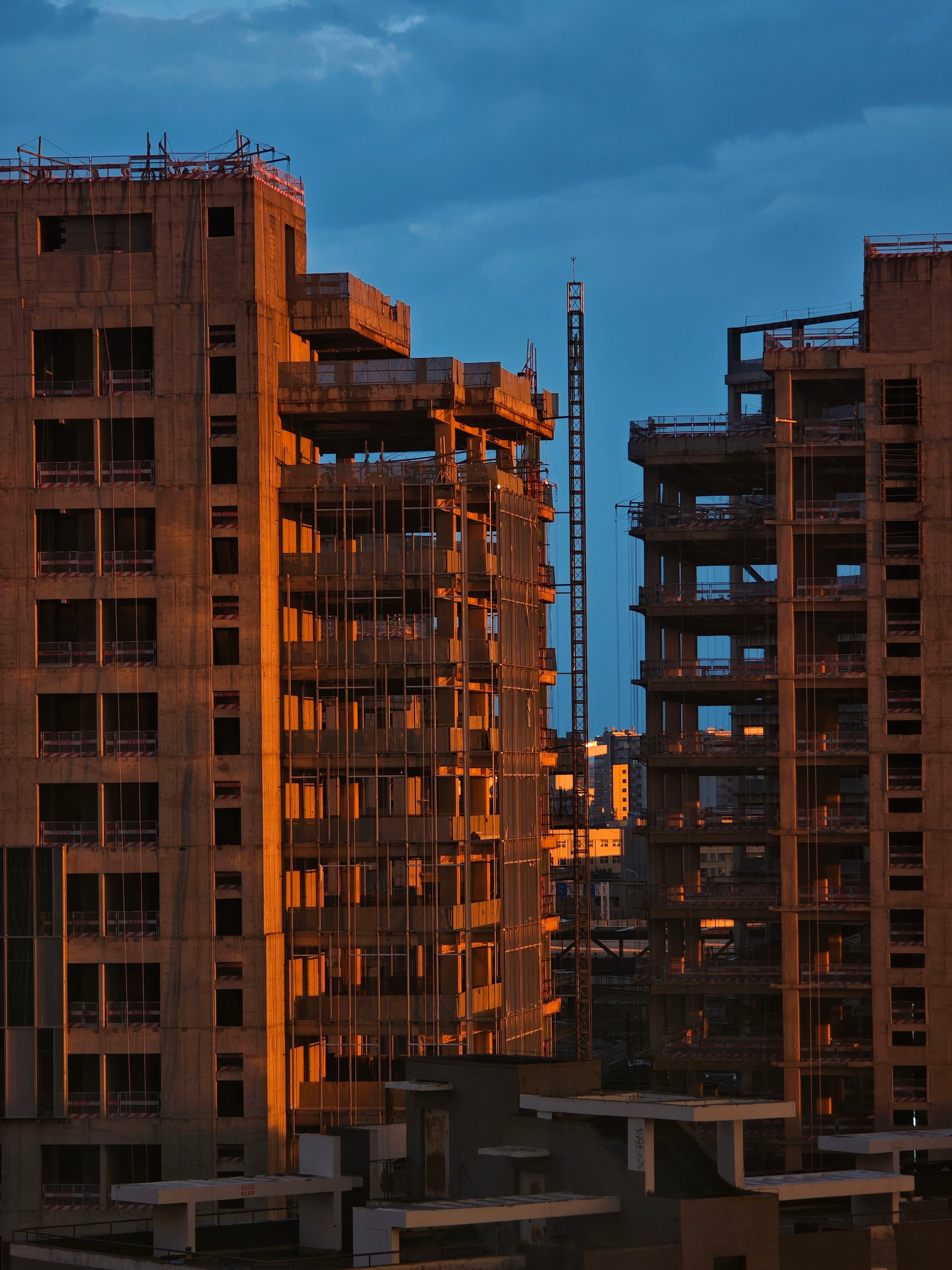 Immeubles en béton en construction éclairés par une lumière dorée