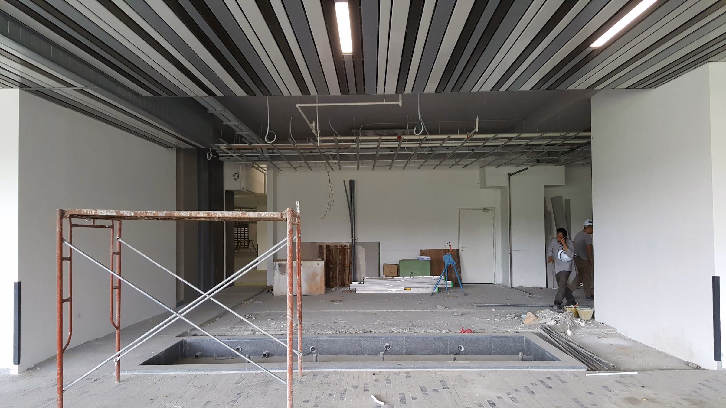 Local commercial en cours d’aménagement avec échafaudage roulant